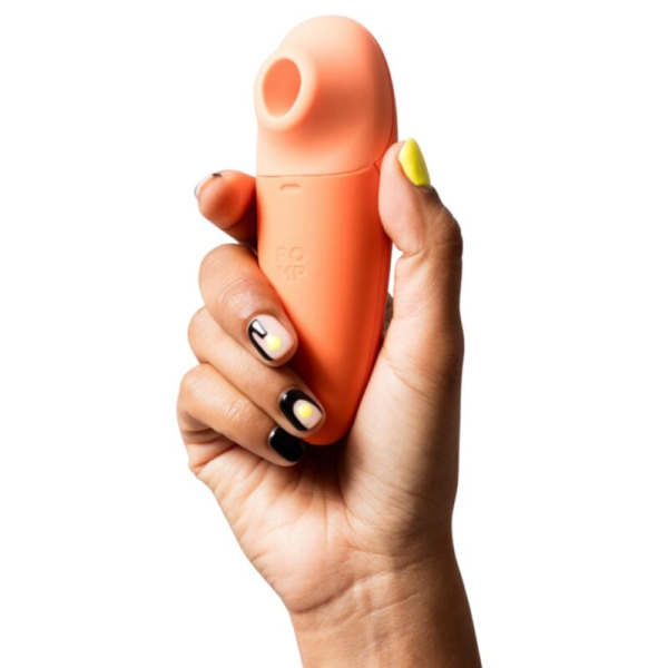 Mano sosteniendo dispositivo íntimo de succión naranja